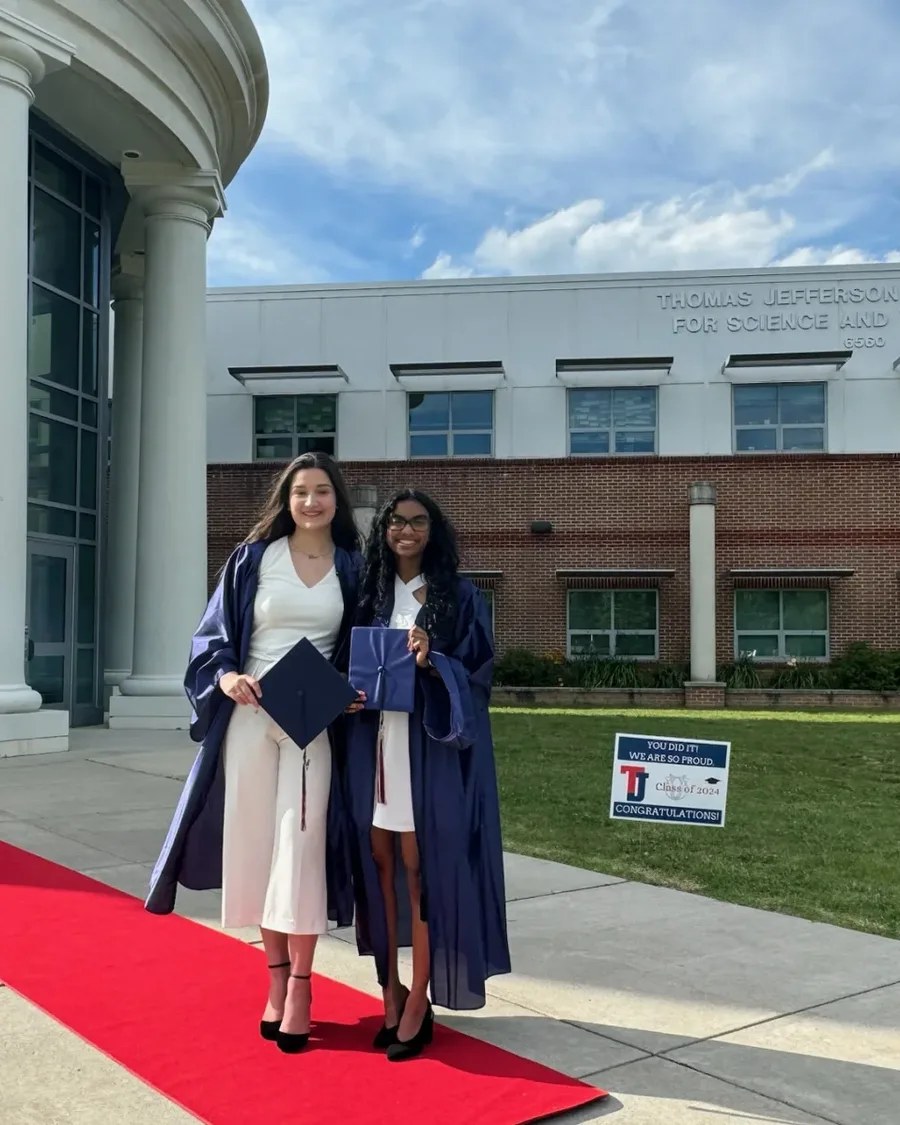 Demi and Vishana in graduation gowns outside Thomas Jefferson High School for Science and Technology
